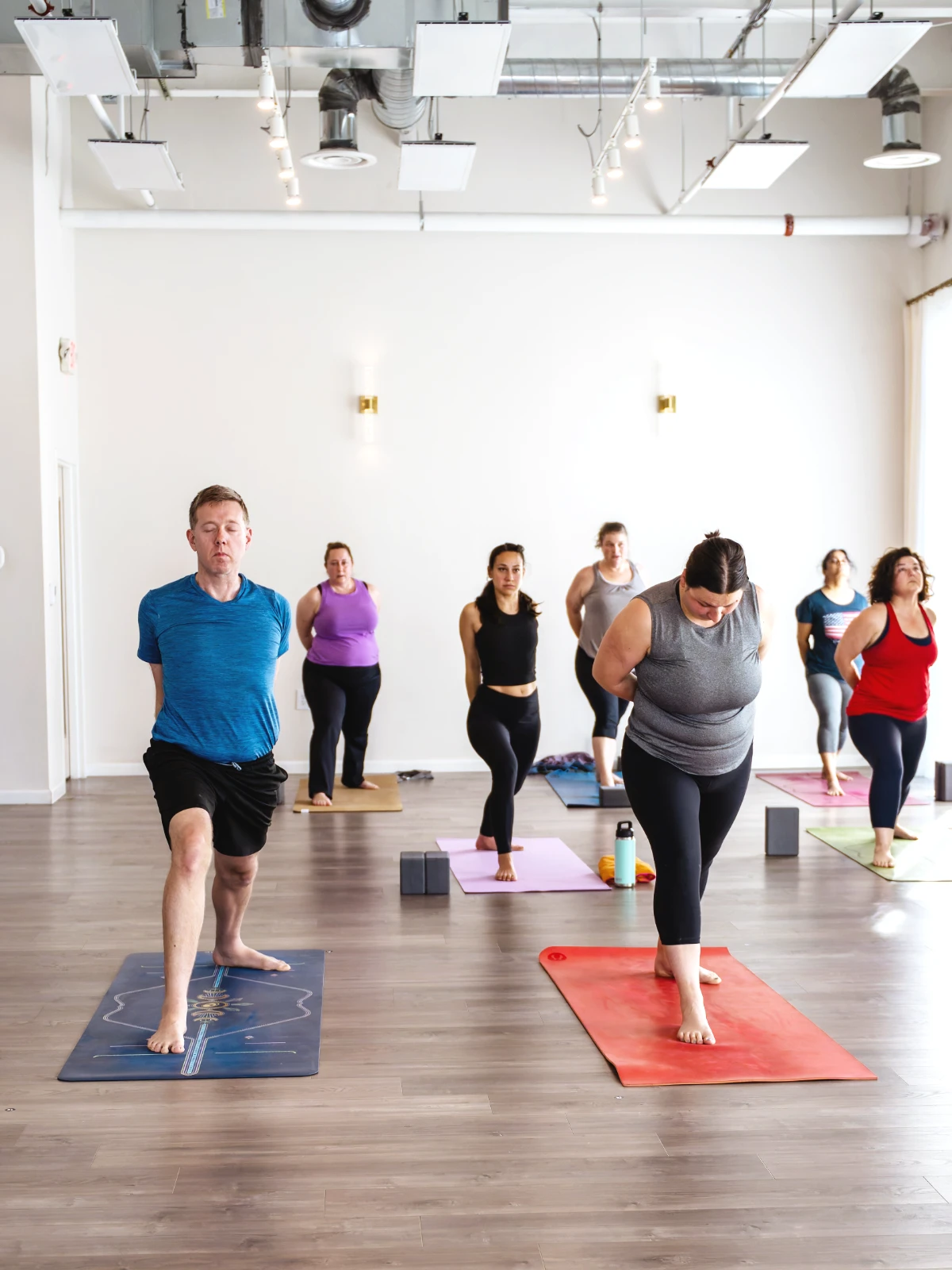 Students in yoga class in standing pose