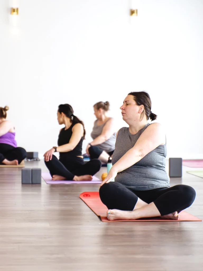 Students seated crosslegged and turning at the waist to stretch